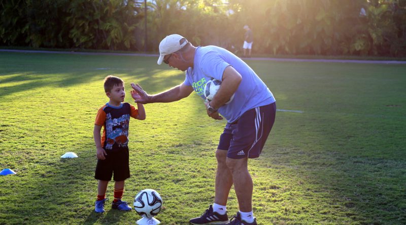 Antonio "Motor" Paz high fives a child.
