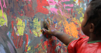 A little girl finger painting.
